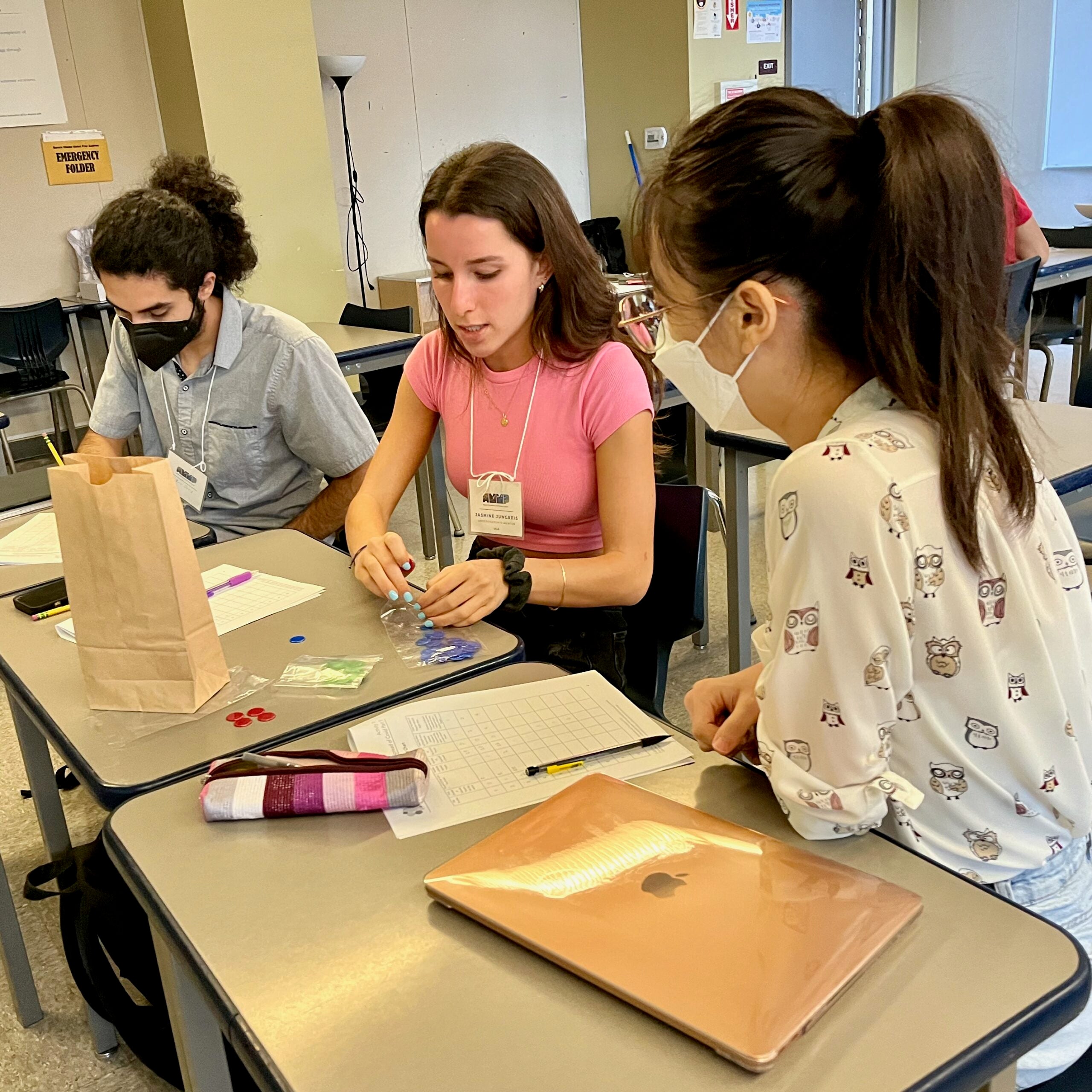 Image displays UCLA undergraduate students working together on an AMMP activity in the Grade 8 Covid investigation.