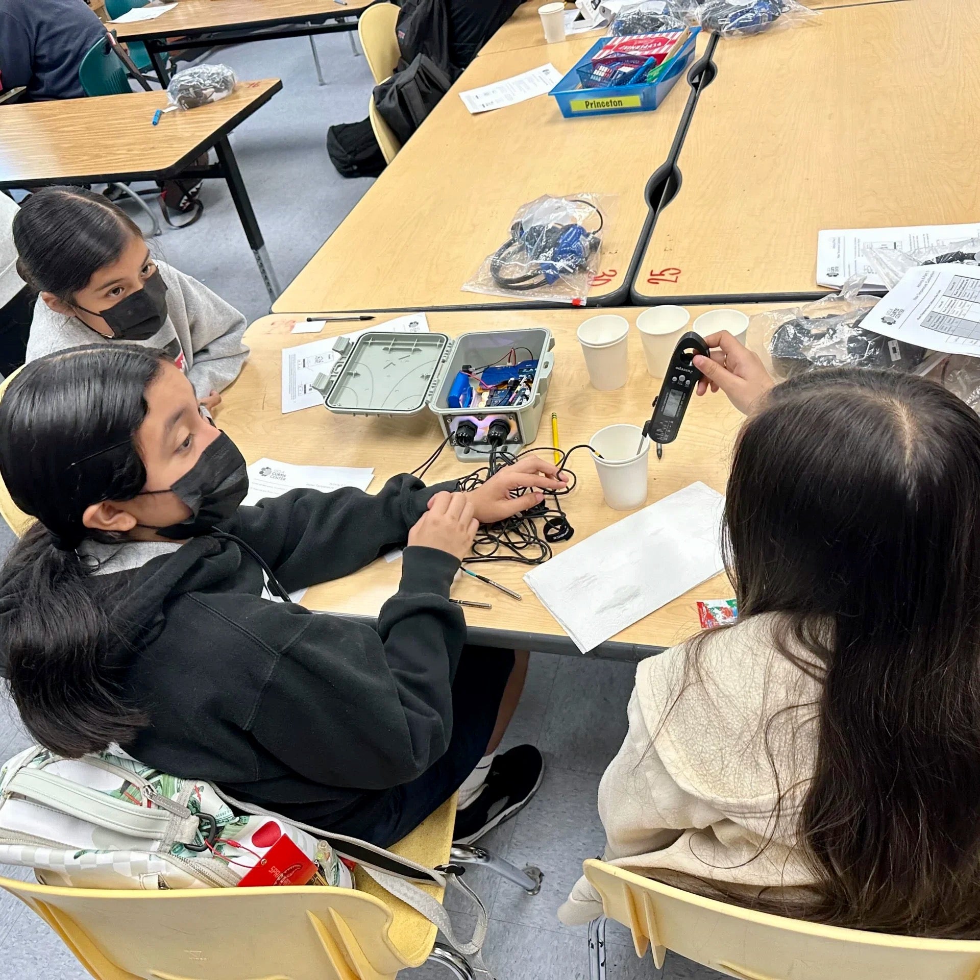 Image display three female students working calibrating and testing out their group's FieldKit.